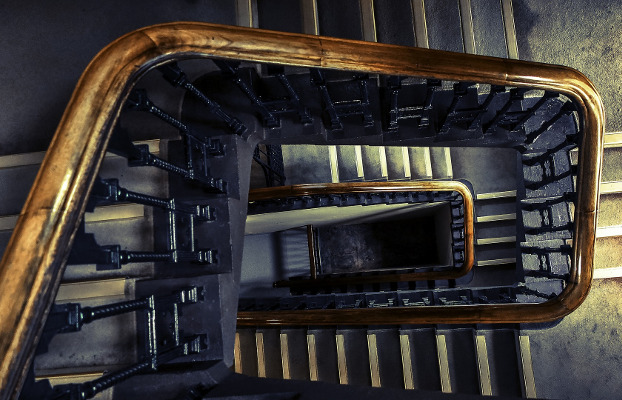 Escalera interior de un edificio, con pasamanos de madera.