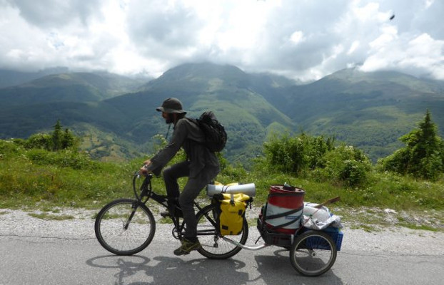 Ciclista pedalant en una carretera de muntanya durant una Ecotopia Biketour